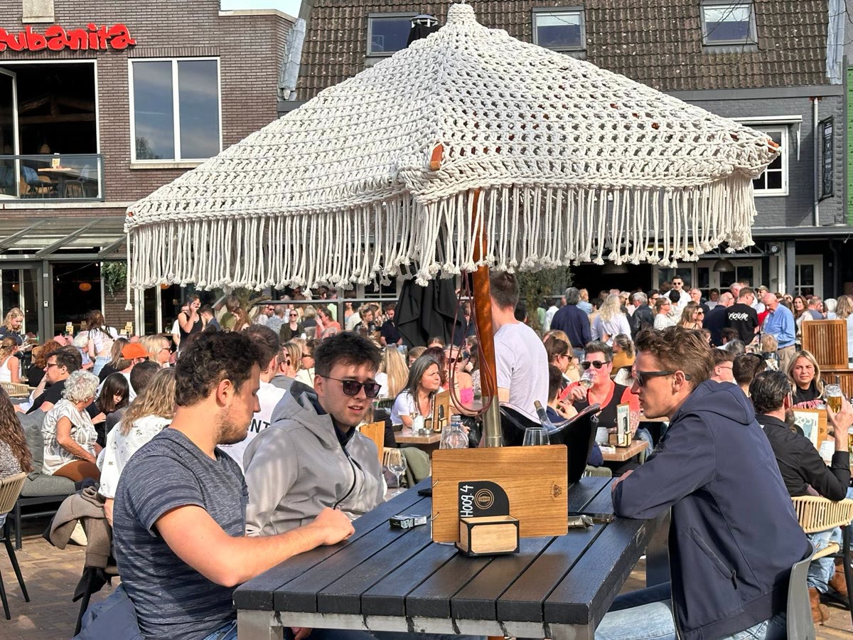 Vol terras met parasols voor Café Premier op een zomerse dag